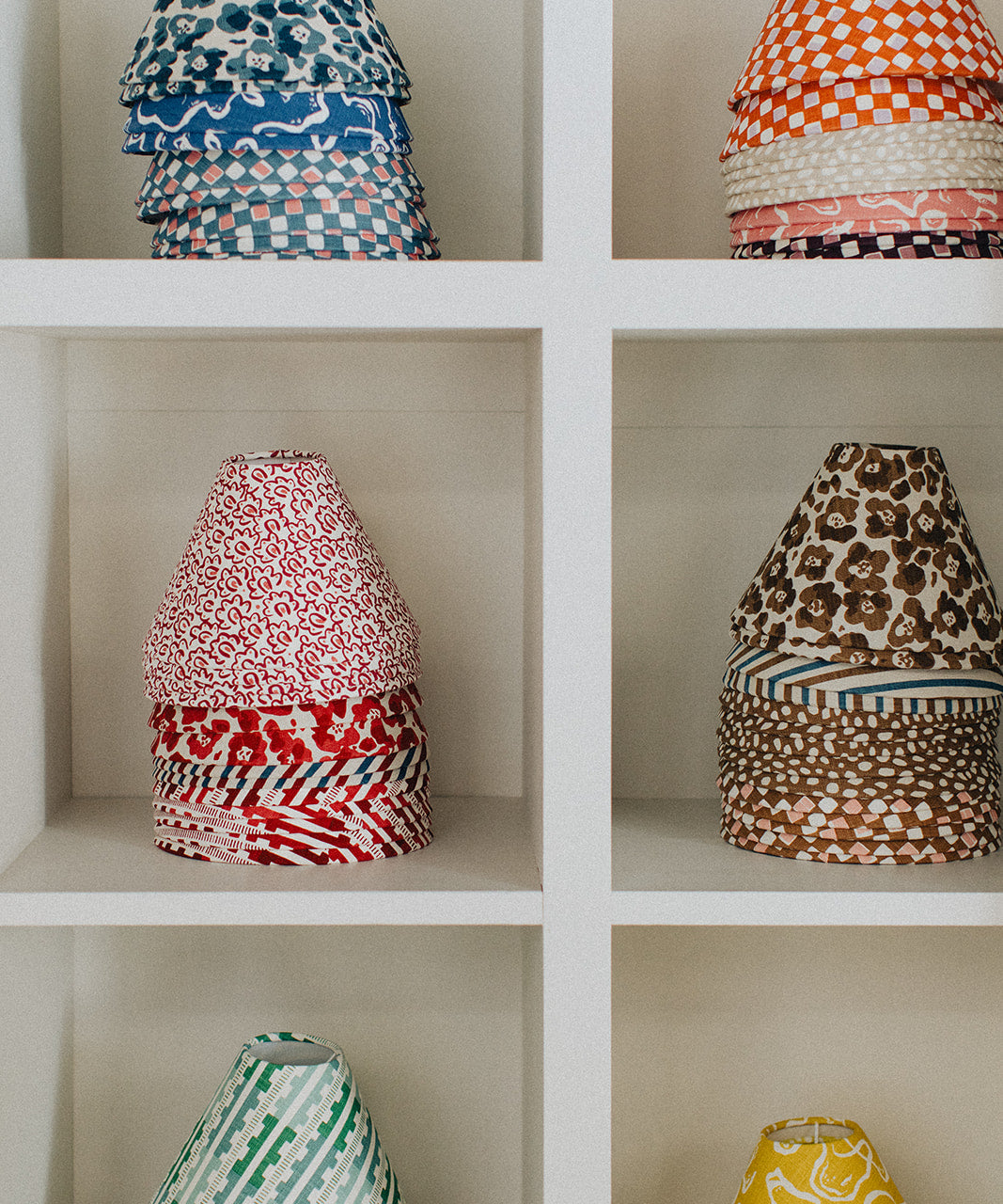 Colorful patterned lampshades on a white shelf